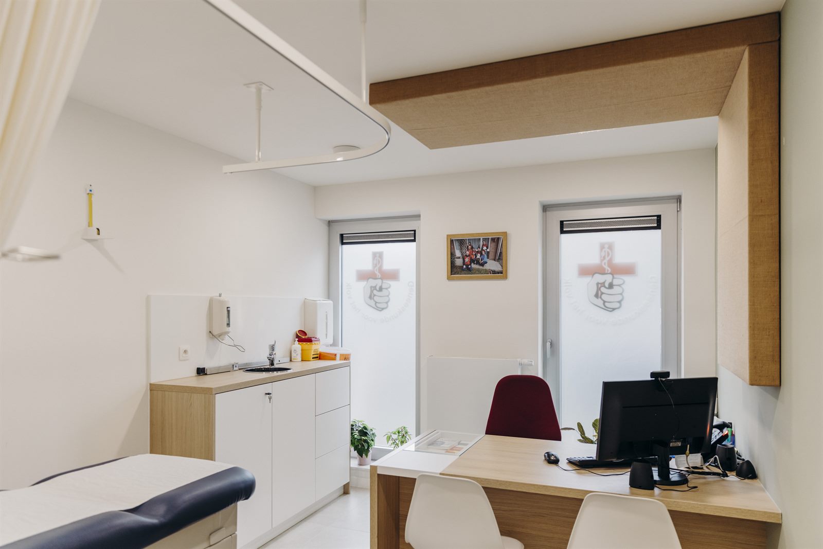 Consultatieruimte met akoestische panelen en meubilair op maat in een dokterspraktijk in Genk