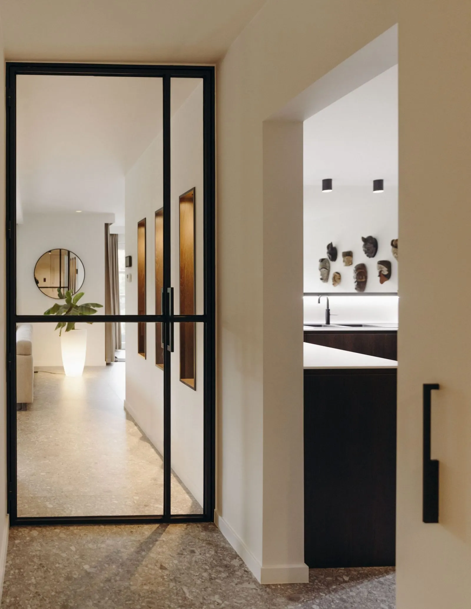 Woninginterieur met stalen taatsdeur en terrazzovloer