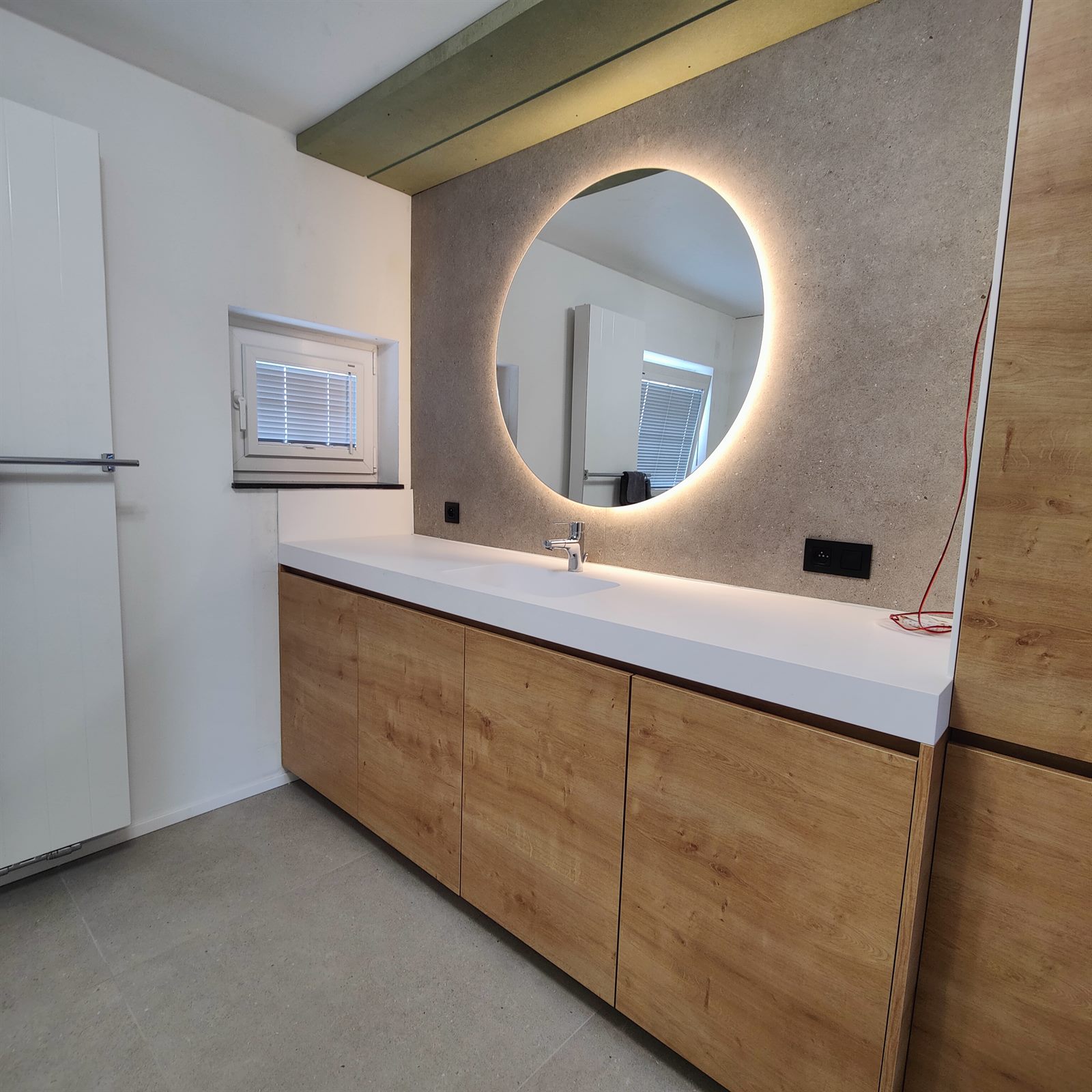 Wastafelmeubel met ronde spiegel in de badkamer in Hasselt