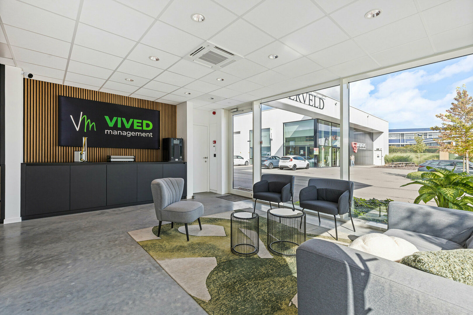 Ontvangstruimte met bedrijfsbranding op houten lamellenwand