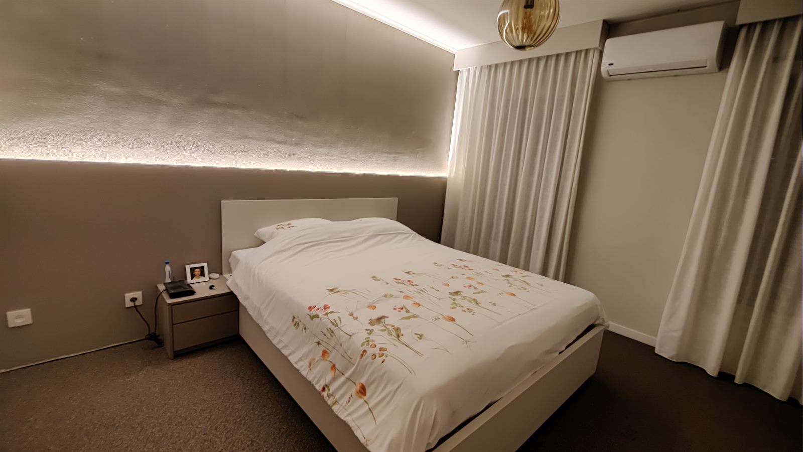 Slaapkamer met verlichte hoofdwand